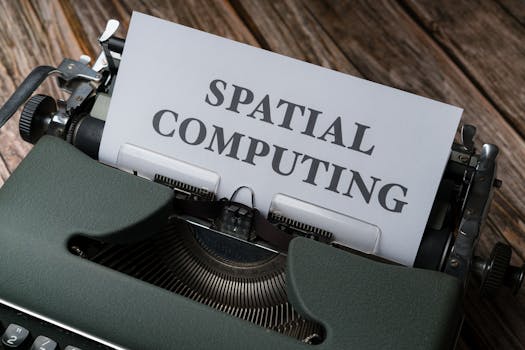 A vintage typewriter with a paper displaying the text 'SPATIAL COMPUTING' on a wooden desk.