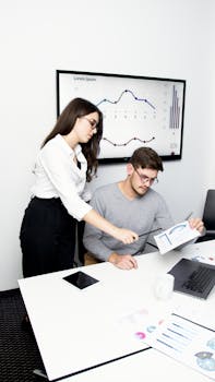Business team collaborating over data during a meeting in a modern office setting.