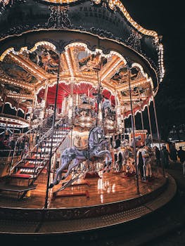 Illuminated carousel ride glowing at night in an amusement park, capturing vibrant carnival atmosphere.