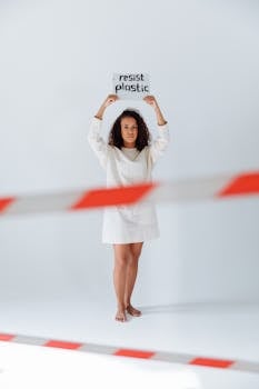 Woman protesting plastic pollution with sign indoors.